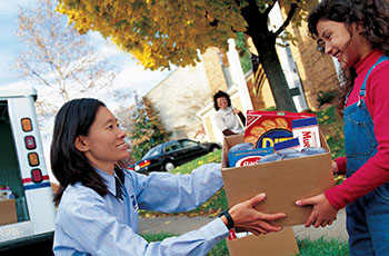 Mail carrier accepting food donation from child