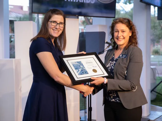 Two women holding a plaque