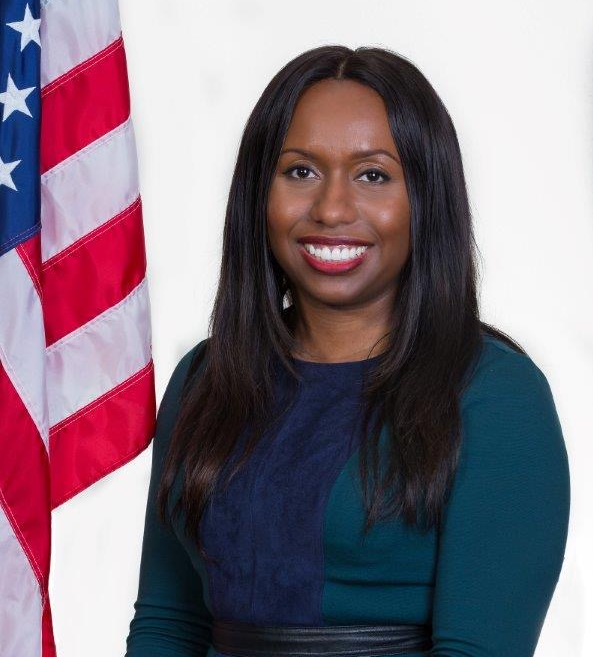 Official portrait of Melanie Calhoun with an American flag in the background.