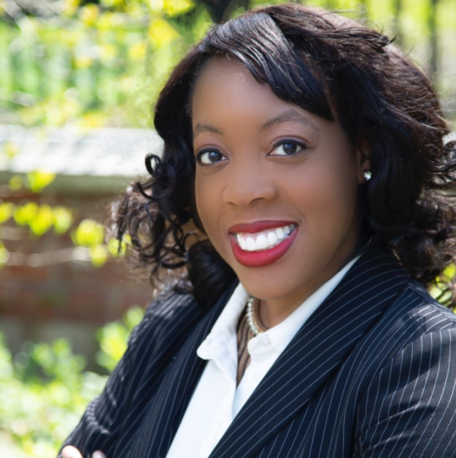 Photograph of Samantha Thomas outside wearing a dark, striped blazer. 