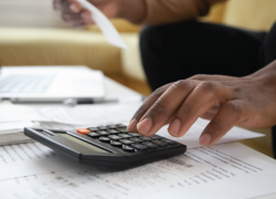 A person pressing buttons on a calculator