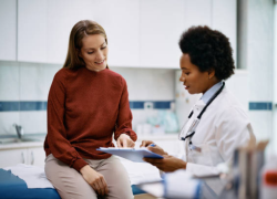 Una proveedora médica habla con una paciente.