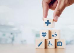 Close up man hand arranging wood block with healthcare medical icon on hospital background. 