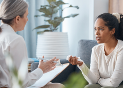 A young woman sitting and talking to her psychologist during a consultation.