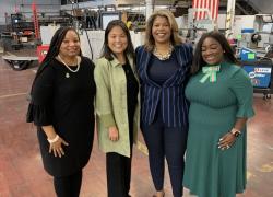 Deputy Secretary Julie Su stands with a group of women.