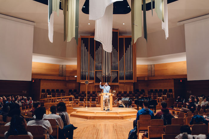 A man speaks in front of the Calvin Chapel.