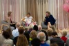 Three people sit around a table in front of an audience during the GLC Breast Cancer Research Symposium 