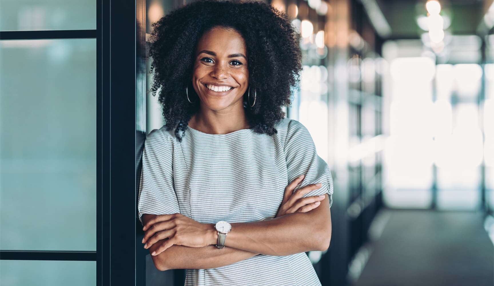 Woman with big smile leaning on wall