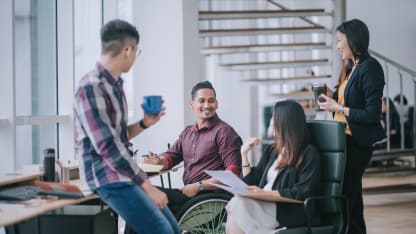 Employee in wheelchair with group of co-workers