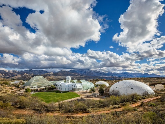 The Biosphere 2 campus beneath a blue, cloudy sky