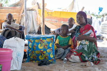 Foto: WFP/Julian Frank. Neu angekommene Binnenvertriebene, die im Schatten warten, Mosambik, Cabo Delgado.