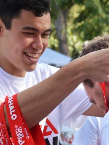 Man putting medal on race finisher