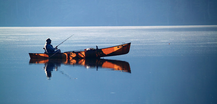 Person fishing on the lake in a kayak