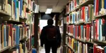 Person walking through library aisle.