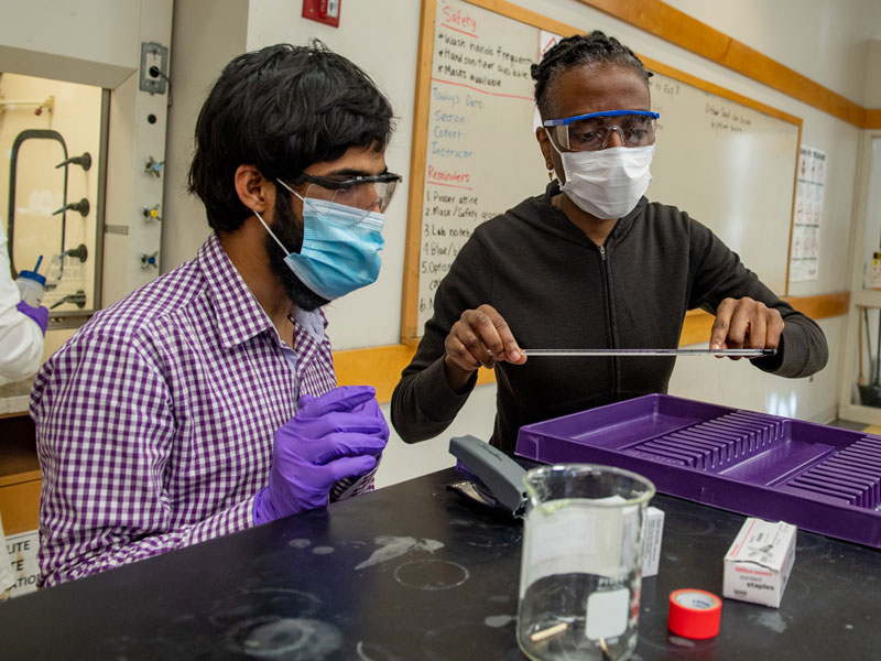 Professor assists student in chemistry lab