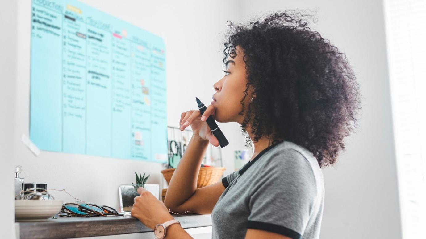 Young woman of colour going through a to-do list for studying abroad