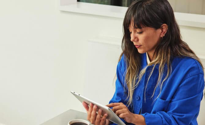 Mujer joven con una tableta en la mesa