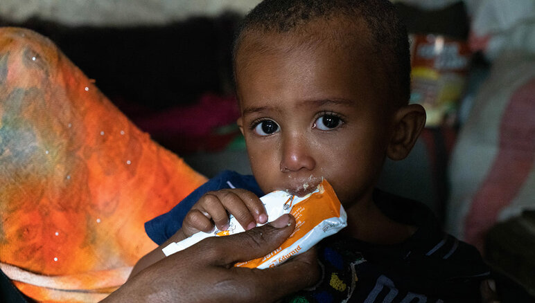 Yémen. La mère de Sultan lui donne une pâte d'arachide nutritive à la maison. Il souffre de malnutrition aiguë modérée. Grâce à l'alimentation complémentaire qu'il reçoit du PAM, Sultan a commencé à prendre du poids et a plus d'énergie qu'avant. Mais il a encore besoin d'un traitement. Sa famille reçoit également une aide alimentaire du PAM : farine, haricots secs, huile, sucre et sel. PAM/Mohammed Awadh