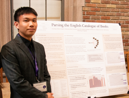 A student stands with his poster.