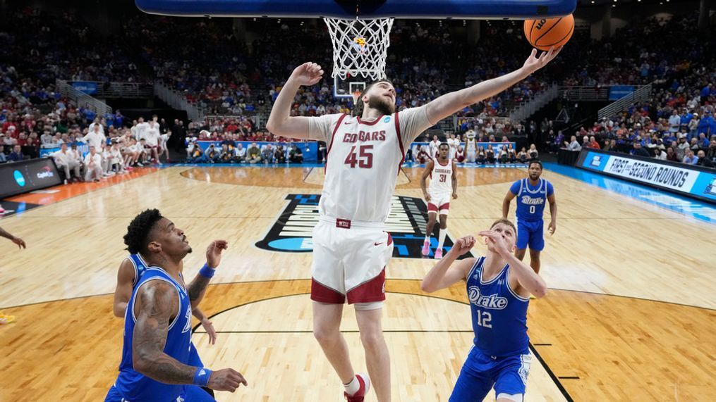 Washington State's Oscar Cluff (45) reaches for the ball as Drake's Darnell Brodie, left, and Tucker DeVries (12) defend during the first half of a first-round college basketball game in the NCAA Tournament Thursday, March 21, 2024, in Omaha, Neb. (AP Photo/Charlie Neibergall)