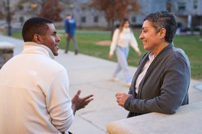 Dean Belmonte and a student speak on campus