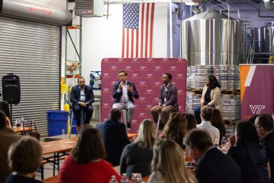 All four panelists are on stage addressing the crowd gathered for Tech on Tap event.