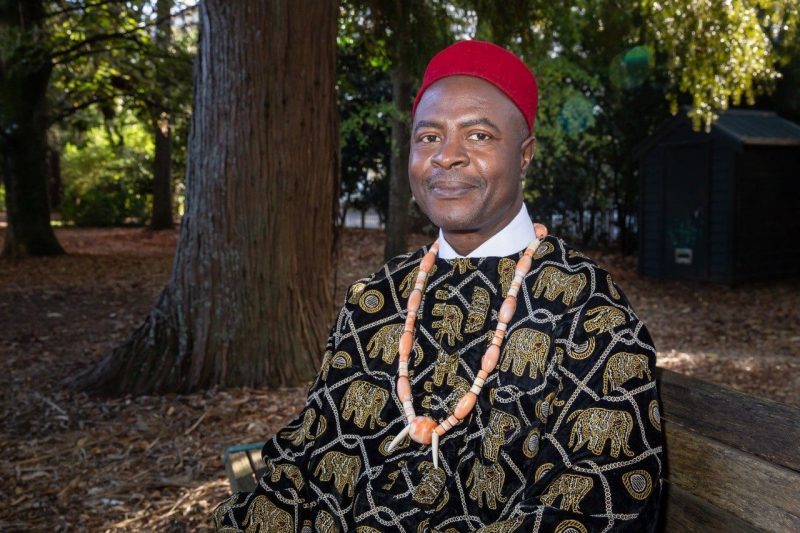 Onwubiko Agozino poses for a photo in front of a tree.