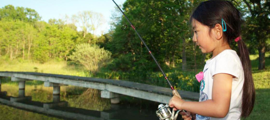 Girl fishing on the edge of a lake