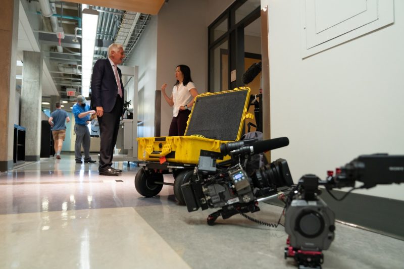 Linsey Marr and John LaPook stand in campus building during 60 minutes interview 