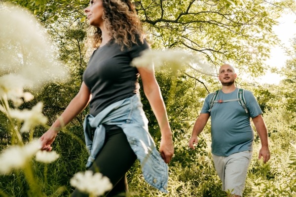 Joven hombre y mujer caucásicos caminando al aire libre.