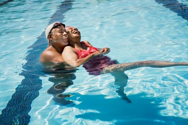 Happy senior couple embracing in pool.