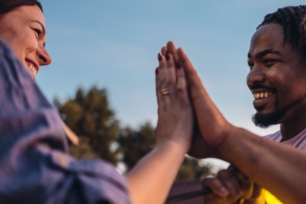 White woman and black man giving a high five.