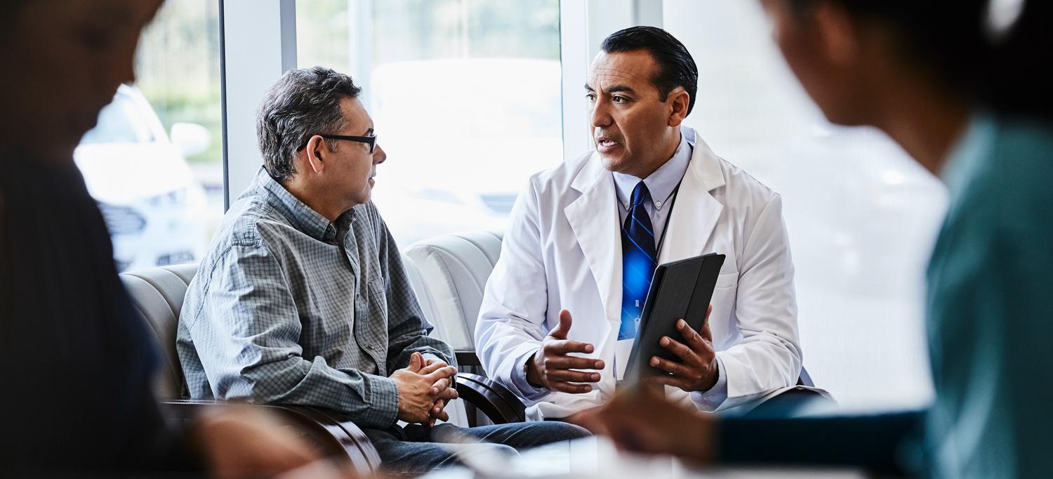 Doctor Holding Tablet and Speaking with Patient