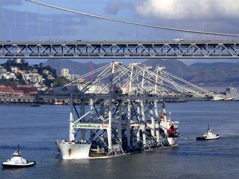 Cranes passing under bridge