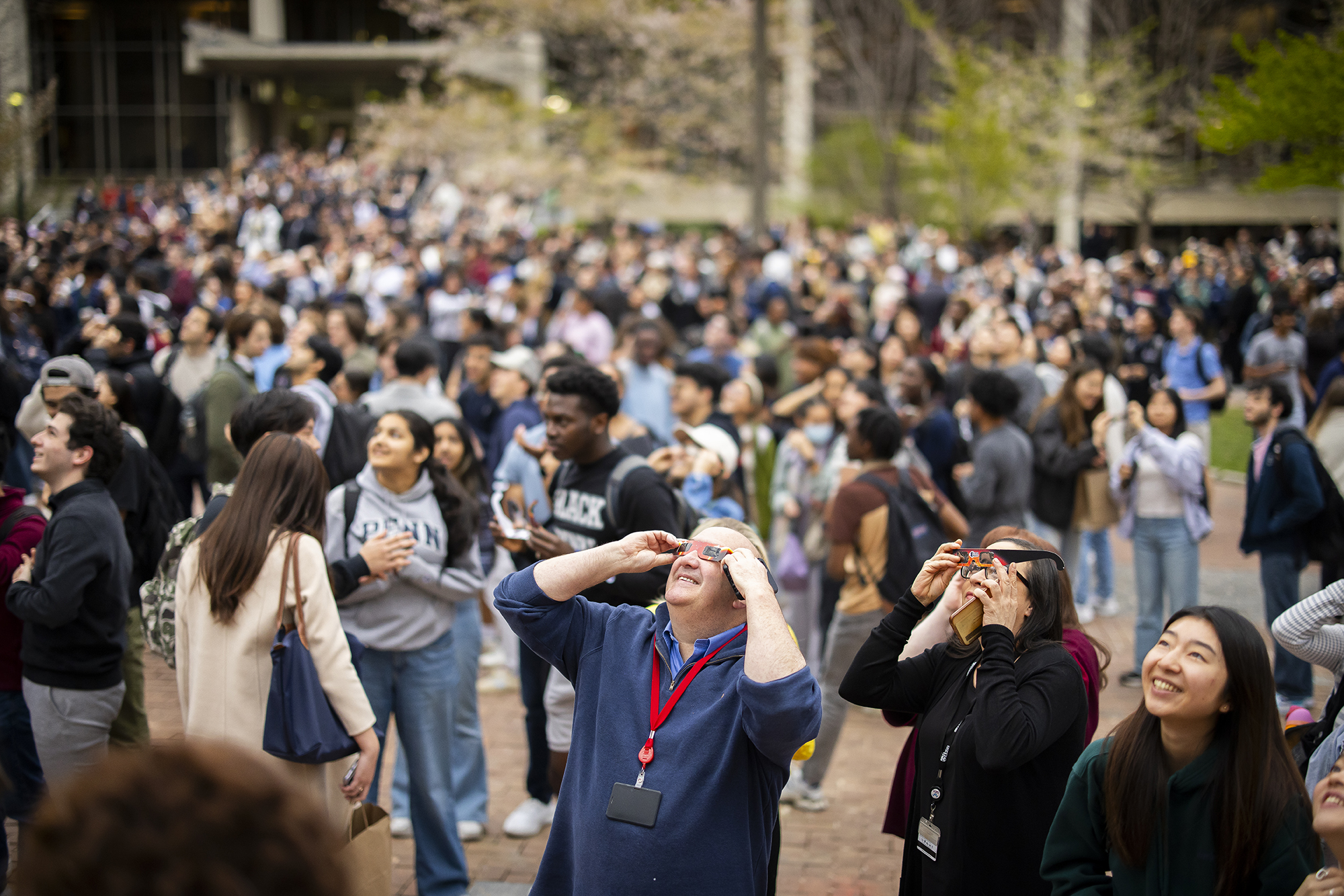 A crowd of people on College Green watching the solar eclipse.