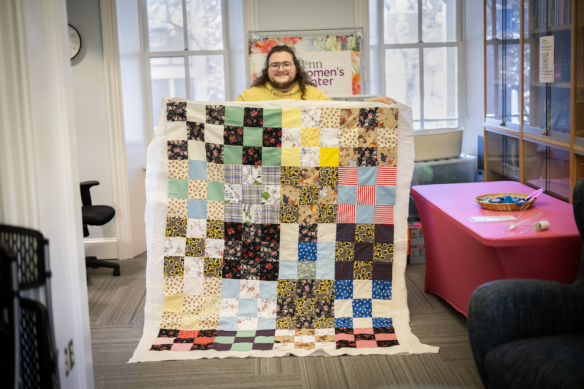 Luke Godsey holds a multicolored quilt up at the PWC