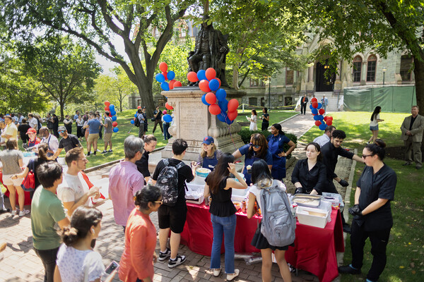 Liz Magill and others scooping ice cream for a crowd on College Green.