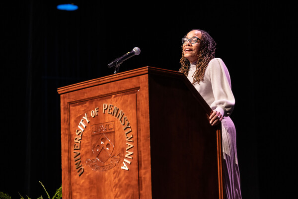 Dorothy Roberts speaks at a podium. The wooden podium has the words "University of Pennsylvania" and its seal. 