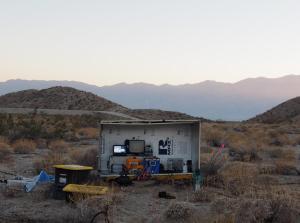 Small shed with equipment and sensors in a dryland landscape at sunset