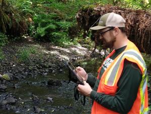 A technician uses theFLOwPER mobile app to record stream data in western Oregon.