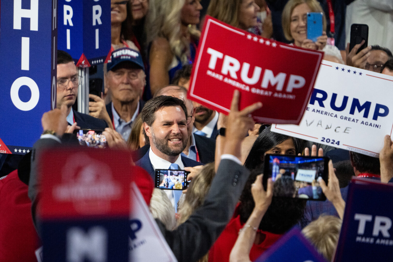 An Iowa delegate's handwritten addition to a Trump campaign sign is visible as Sen. J.D. Vance, R-Ohio, arrives on the floor of the Republican National Convention in Milwaukee ahead of his nomination to be the party's vice presidential candidate. 