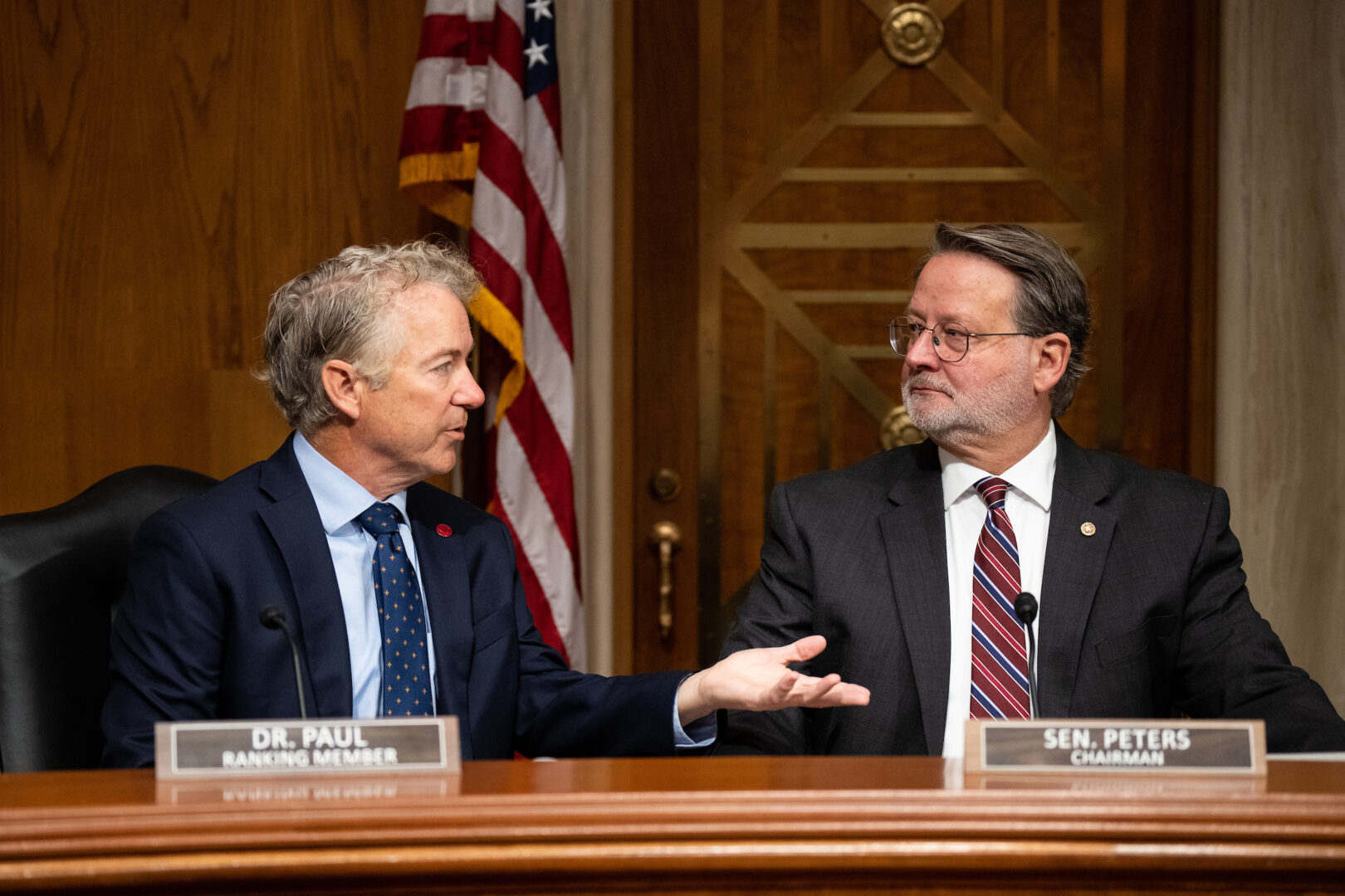 Senate Homeland Security and Governmental Affairs Chairman Gary Peters, D-Mich., right, and ranking member Sen. Rand Paul, R-Ky., talk before a hearing. 