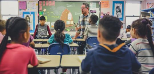 Teacher and pupils in a classroom (Muhammad / Adobe Stock)