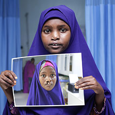 A girl holding a photo of herself. Links to Gifts of Life Insurance