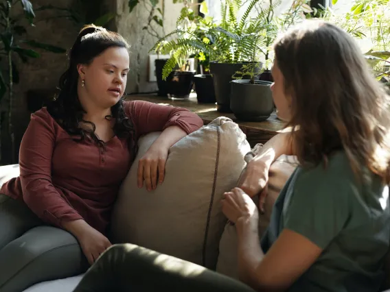 Two Women Sitting on a Couch Chatting