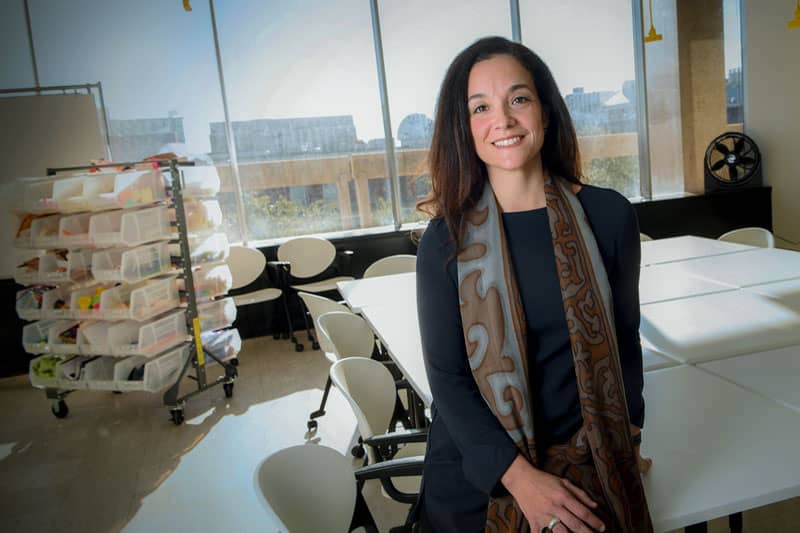 Portrait of Dr. Bazzano sitting on table corner with window in background