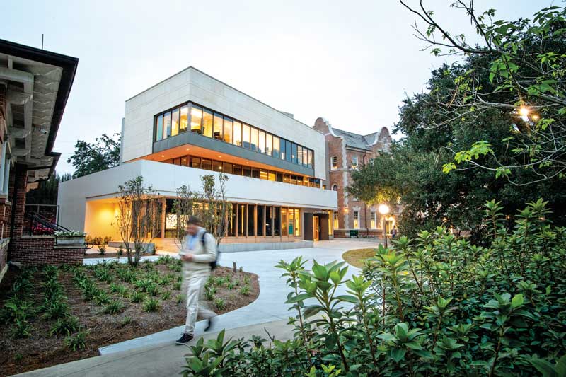 Student walking on winding path with building in background