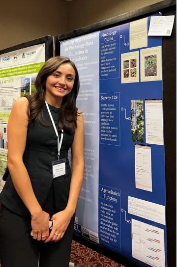 Alyssa Salazar poses next to a blue poster presentation at the 2024 AWC conference.