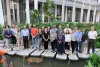 Heat experts pose for a group photo on stepping stones in a pond in front of the Yale-NUS building.