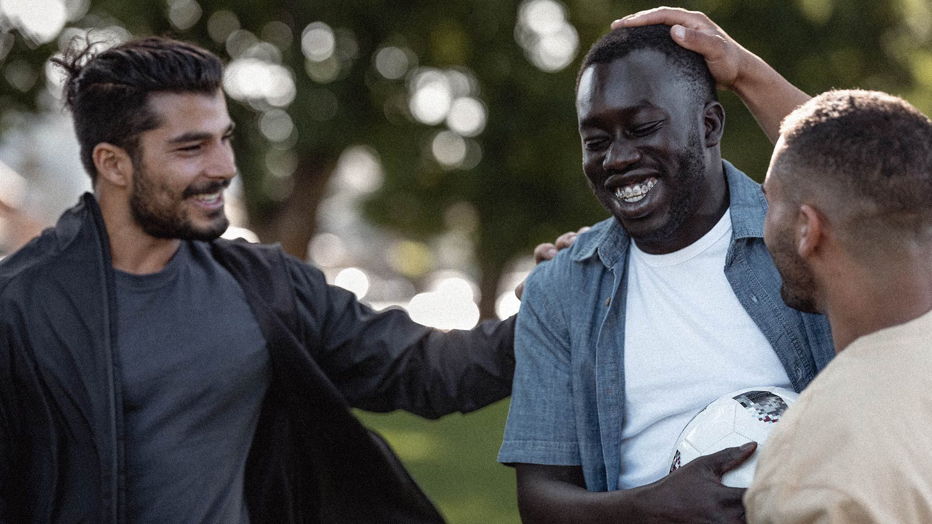 Young men, smiling to camera, after a soccer game.